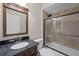 Bathroom featuring tiled shower with glass door and sleek vanity with dark wood and granite countertop at 13722 Fox Glove St, Winter Garden, FL 34787