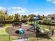 Playground with swings, slide, and climbing dome, surrounded by lush landscaping at 13722 Fox Glove St, Winter Garden, FL 34787