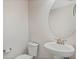 Half bathroom features white fixtures including a pedestal sink and a toilet with brushed nickel hardware at 14040 Helsby St, Orlando, FL 32832