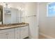 Bathroom featuring double sink vanity with granite countertops, a window and a large mirror at 14040 Helsby St, Orlando, FL 32832