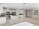 Well-lit kitchen with an island, granite countertops, stainless steel appliances and beige tile flooring at 14040 Helsby St, Orlando, FL 32832