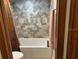 Updated bathroom with modern tile backsplash and a new white tub and toilet at 1500 Markham Woods Rd, Longwood, FL 32779