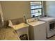 Bright laundry room with washer, dryer, utility sink, and a large window at 1500 Markham Woods Rd, Longwood, FL 32779