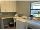 Bright laundry room with washer, dryer, utility sink, and a large window at 1500 Markham Woods Rd, Longwood, FL 32779