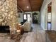 Inviting living room featuring a stone fireplace, wood ceiling, and neutral-toned sofa at 1500 Markham Woods Rd, Longwood, FL 32779