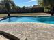 Sparkling pool with brick paver patio, surrounded by lush green trees, perfect for outdoor relaxation at 1500 Markham Woods Rd, Longwood, FL 32779