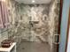 Updated shower featuring decorative tile, a glass door, and convenient built-in shelving at 1500 Markham Woods Rd, Longwood, FL 32779