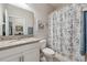 Bathroom featuring a granite vanity top, framed mirror, and a shower-tub combo at 15456 Blackbead St, Winter Garden, FL 34787