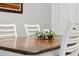 Bright dining room with white chairs, wooden table and a decorative centerpiece at 15456 Blackbead St, Winter Garden, FL 34787