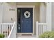 Inviting front door with sidelight, wreath, and bench on a covered front porch at 15456 Blackbead St, Winter Garden, FL 34787