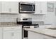 Close up of the kitchen shows granite countertops, stainless appliances, and tile backsplash at 15456 Blackbead St, Winter Garden, FL 34787