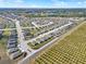 Comprehensive aerial view of a community featuring modern homes, green spaces, and scenic water views in the distance at 1579 Swan Lake Cir, Dundee, FL 33838