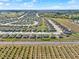 Expansive aerial view of a well-planned community with modern homes and manicured lawns, enhanced by serene surroundings at 1579 Swan Lake Cir, Dundee, FL 33838