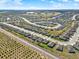 High-angle aerial view showcasing a residential area with uniform houses, complemented by distant landscapes and blue skies at 1579 Swan Lake Cir, Dundee, FL 33838