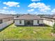 Backyard view of the home surrounded by a white fence and a large grass lawn at 1579 Swan Lake Cir, Dundee, FL 33838