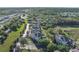 This aerial shot displays a complex and surrounding scenery full of trees, greens, and nearby roads at 1598 Heritage Crossing Ct # 302, Reunion, FL 34747