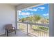 A serene balcony features a chair with views of lush greenery and a walking path, creating an inviting outdoor space at 1598 Heritage Crossing Ct # 302, Reunion, FL 34747