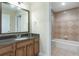 Well-appointed bathroom features a vanity with granite countertop and a separate bathtub with tiled surround at 1598 Heritage Crossing Ct # 302, Reunion, FL 34747