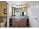 Bathroom features a vanity with granite countertop, large mirror, and a toilet room, offering style and functionality at 1598 Heritage Crossing Ct # 302, Reunion, FL 34747