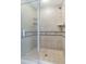 Bathroom shower featuring glass doors, tile, shelving, and showerhead at 1598 Heritage Crossing Ct # 302, Reunion, FL 34747