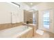 Bright bathroom with a soaking tub, glass-enclosed shower, and access to the pool area at 1639 Lima W Ave, Kissimmee, FL 34747