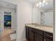 Bathroom with granite countertops, dark wood cabinets, tile floors, and decorative light fixture at 1639 Lima W Ave, Kissimmee, FL 34747