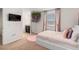 Cozy bedroom with neutral carpet, TV, updated bathroom and whimsical hanging floral decor at 1639 Lima W Ave, Kissimmee, FL 34747