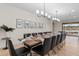 Dining area with long wooden table, black chairs, and decorative lighting for elegant dinners at 1639 Lima W Ave, Kissimmee, FL 34747