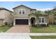 Charming two-story home featuring a well-maintained lawn and a two-car garage on a sunny day at 1639 Lima W Ave, Kissimmee, FL 34747