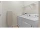 Efficient laundry room with a washing machine, dryer, and ironing board at 1639 Lima W Ave, Kissimmee, FL 34747