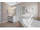 Bright bathroom featuring soaking tub, white cabinets, decorative towel, and tiled flooring at 2011 Soaring Oak Way, Winter Park, FL 32792
