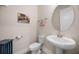 Powder room with pedestal sink, round mirror, and toilet at 2011 Soaring Oak Way, Winter Park, FL 32792