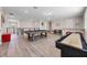 Spacious game room with a pool table, shuffleboard, and staircase at 2011 Soaring Oak Way, Winter Park, FL 32792