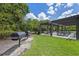 Community outdoor grill and picnic area featuring charcoal grills and picnic tables under a pergola at 2011 Soaring Oak Way, Winter Park, FL 32792