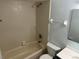 Bathroom with a shower/tub combo, toilet, and tile surround at 214 Magellan Dr, Kissimmee, FL 34758