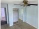 Bedroom with mirrored closet doors, ceiling fan and tile flooring at 214 Magellan Dr, Kissimmee, FL 34758