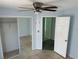 Bedroom featuring tile floors, a closet, a ceiling fan, and a doorway leading to the hallway at 214 Magellan Dr, Kissimmee, FL 34758