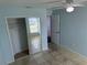 Bright bedroom features tile flooring, a ceiling fan, and a closet with sliding mirror doors at 214 Magellan Dr, Kissimmee, FL 34758
