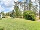 Lush backyard features a well-manicured lawn and mature trees, creating a serene outdoor space at 231 Cherokee Hill Ct, Deland, FL 32724