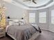 Cozy bedroom with decorative wall lighting, tray ceiling, and plush bedding for a relaxing ambiance at 231 Cherokee Hill Ct, Deland, FL 32724