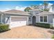 Charming exterior view of a grey home featuring an arched entryway and a brick paver driveway at 231 Cherokee Hill Ct, Deland, FL 32724