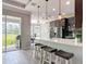 Gourmet kitchen with white quartz countertops, stainless steel appliances, and bar seating overlooking a backyard view at 231 Cherokee Hill Ct, Deland, FL 32724