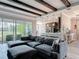 Open-concept living room featuring beamed ceilings, a modern kitchen, and seamless access to an outdoor patio at 231 Cherokee Hill Ct, Deland, FL 32724