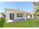 Backyard featuring covered patio, green grass, and white exterior at 2430 Sanderling St, Haines City, FL 33844