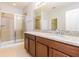 Bathroom with glass enclosed shower, granite countertop and wood cabinets at 2430 Sanderling St, Haines City, FL 33844