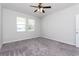 Neutral bedroom with gray carpeting, ceiling fan, and natural light from multiple windows at 2430 Sanderling St, Haines City, FL 33844