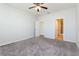 Neutral bedroom with gray carpeting, ceiling fan, and adjoining bathroom at 2430 Sanderling St, Haines City, FL 33844