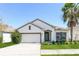 Charming single-story home with a manicured lawn and a white exterior complemented by a neatly trimmed palm tree at 2430 Sanderling St, Haines City, FL 33844