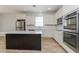 Stylish kitchen with stainless steel appliances, a central island, and sleek white cabinets at 2430 Sanderling St, Haines City, FL 33844