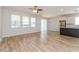 Spacious living room with wood-look tile floors, plenty of natural light, ceiling fan, and an adjacent modern kitchen at 2430 Sanderling St, Haines City, FL 33844